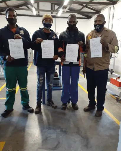 MM Engineering trainees holding their trade test paperwork on graduation day